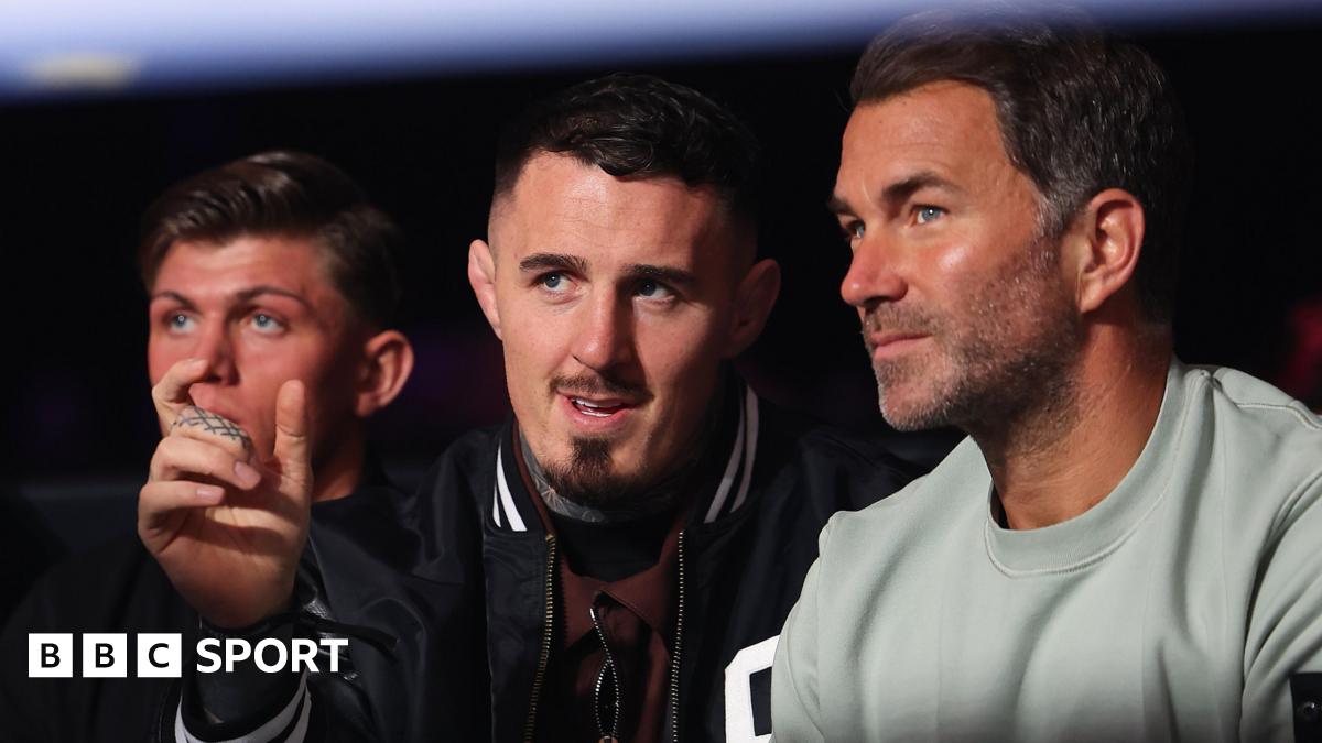 Eddie Hearn and Tom Aspinall talk while they watch a boxing match in April 2026