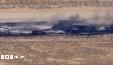 A charred runway, with a fire truck seen responding