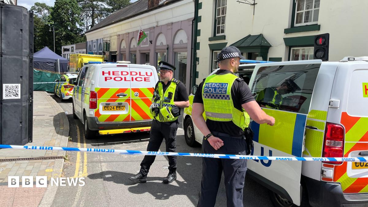 Police officers standing next to a cordoned-off area in Church Street, Welshpool