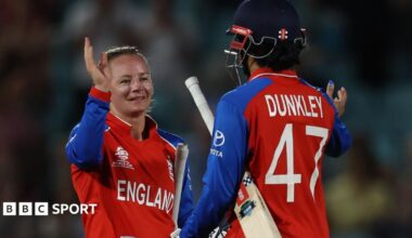 Ellyse Perry grimaces as she walks off the field alongside the Australia physio