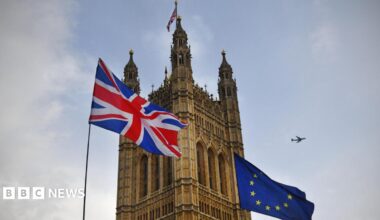 The Union Flag flies next to the EU flag outside one of the towers at the Palace of Westminster.