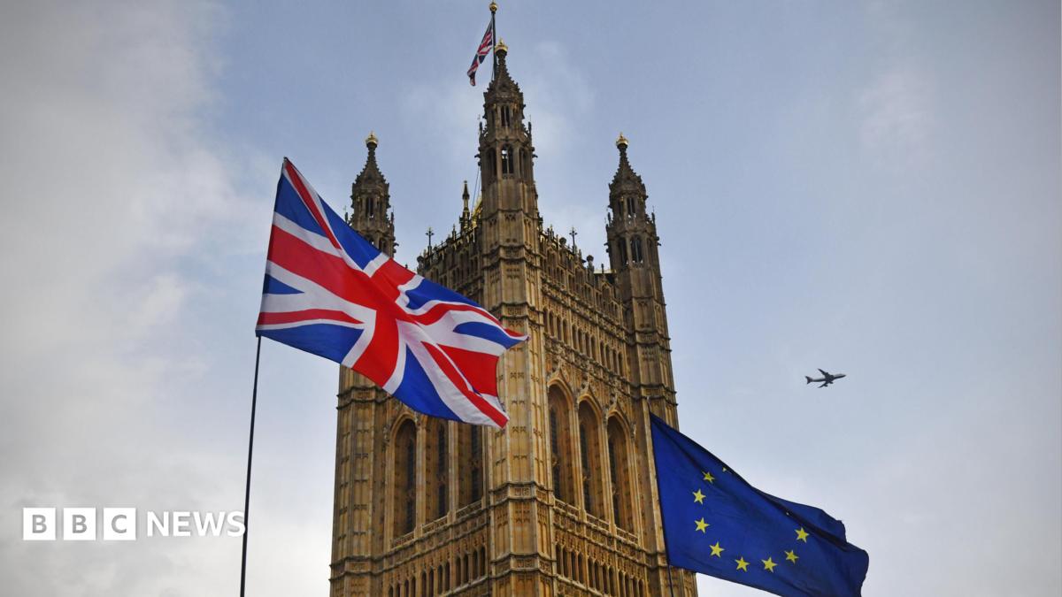 The Union Flag flies next to the EU flag outside one of the towers at the Palace of Westminster.