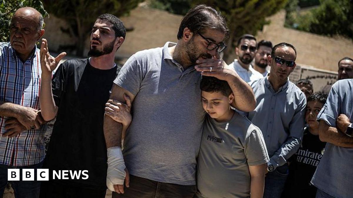 Fahd Abou Haikal, a Palestinian man comforts his elder son Kinan Abou Haikal after burying his seven-month-old baby Sam Fahd Abou Haikal, in Hebron, in the occupied West Bank