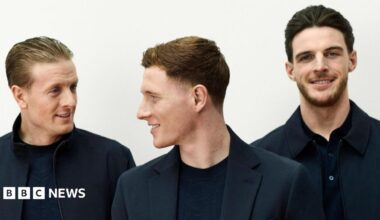 England men's squad wearing dark jackets and trousers, standing with their arms folded in front of them