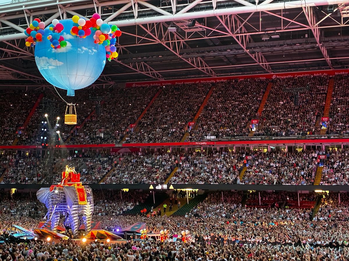 A giant elephant walks along the stage in front of crowds at the Principaility Stadium