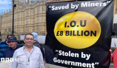 Campaigner Mick Newton outside the Houses of Parliament with a banner which reads " Saved by Miners, I.O.U £8 billion, Stolen by Government".