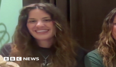Georgia and Melissa Laurie, both sat in front of a webcam, smiling for the camera as they speak during an interview with BBC Breakfast. They both have long, brown or brown/blonde hair. Georgia is wearing a black T-shirt and Melissa a green T-shirt.