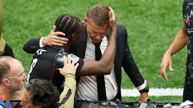 8: Ismael Kone #8 of Canada consoled by Jesse Marsch, Head Coach of Canada, as he is stretched off after being fouled by Assim Madibo