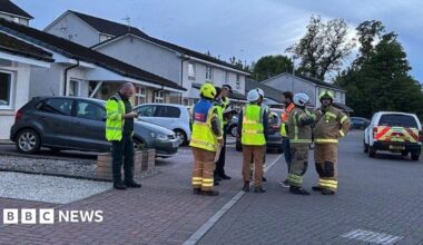 Emergency services gather in a residential street with a taped off cordon in the foreground