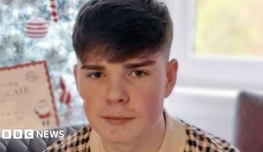 Kayden Moy looks in the camera and smiles - he is a teenage boy with short dark hair.