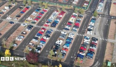 Aerial view of Cardiff East Park and Ride in Llanrummney. The park and ride is mostly full with rows of cars.