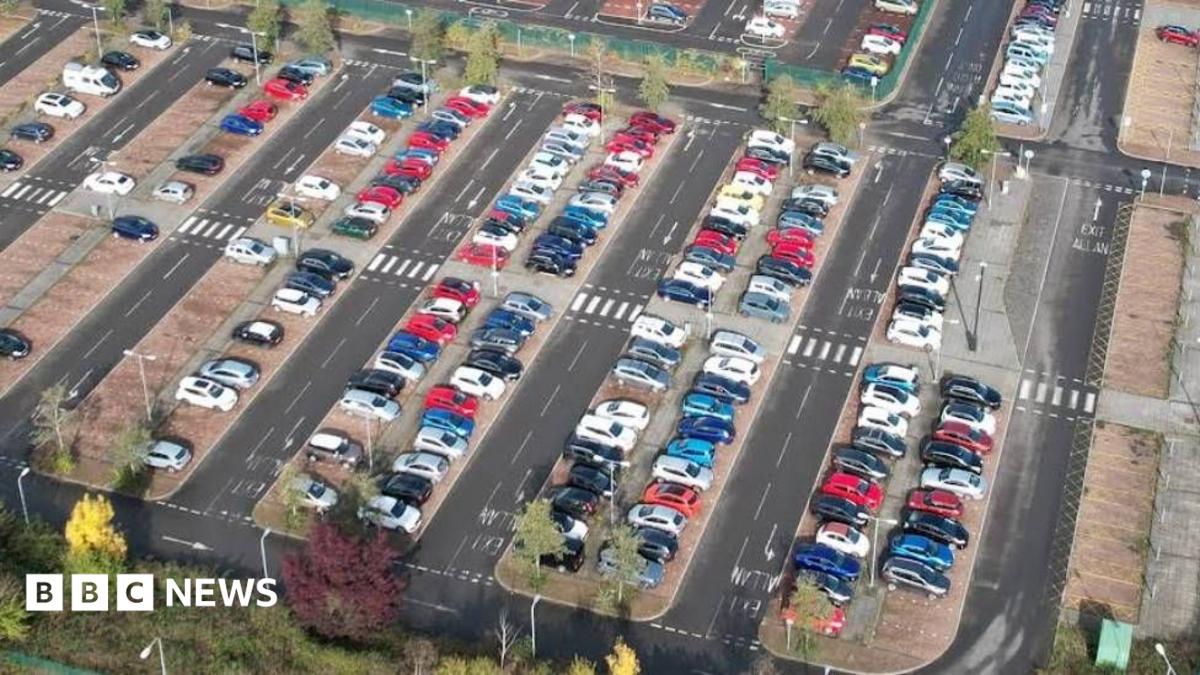 Aerial view of Cardiff East Park and Ride in Llanrummney. The park and ride is mostly full with rows of cars.