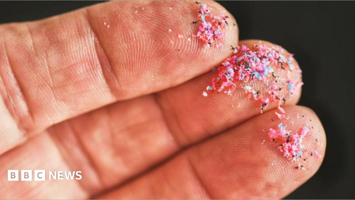 A hand with microplastics on the fingers.