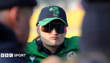 Close up of Gaby Lewis, pictured wearing sunglasses in a team huddle