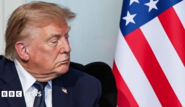 Close up of US President Donald Trump and an American flag as he attends a bilateral meeting with French President Emmanuel Macron