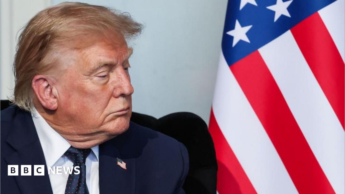 Close up of US President Donald Trump and an American flag as he attends a bilateral meeting with French President Emmanuel Macron