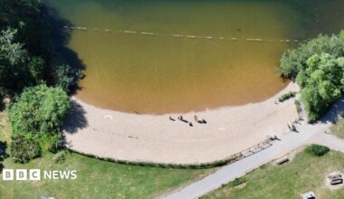 A sandy beach on a lake.