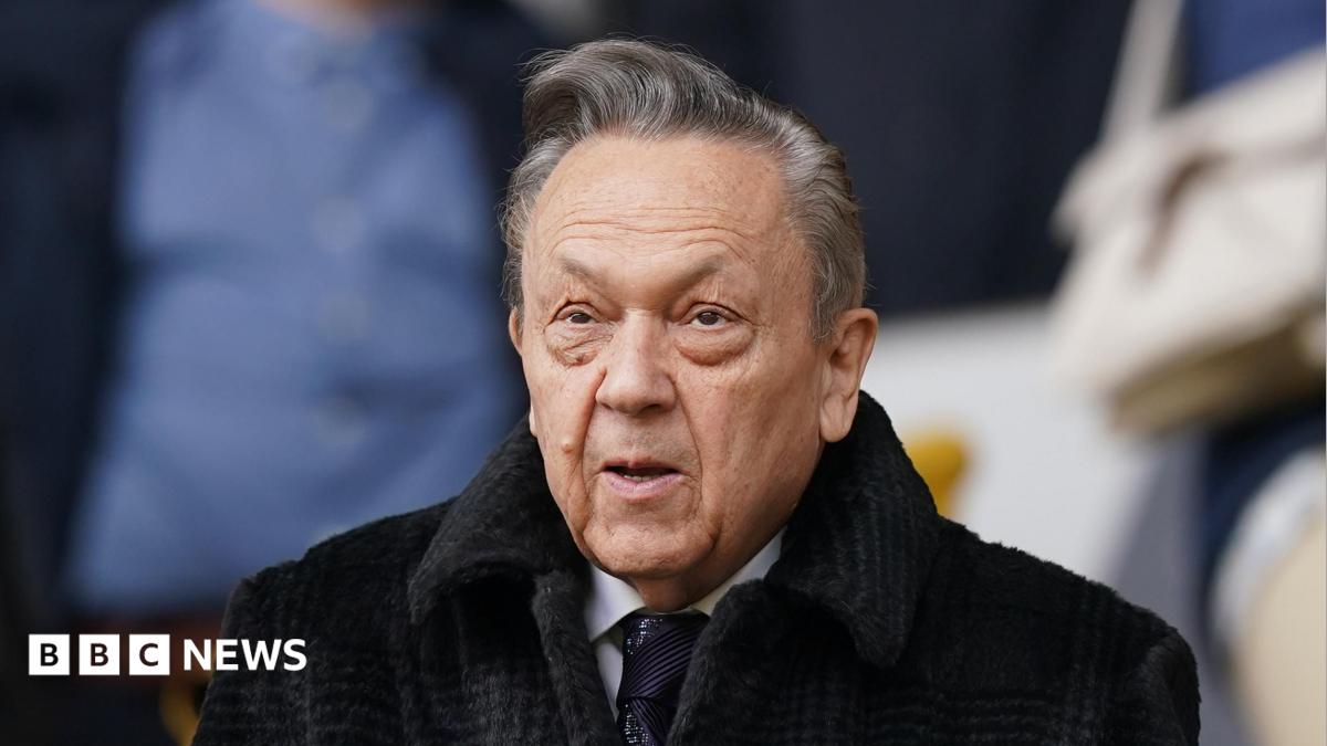 Former West Ham United chairman David Sullivan in the stands before the team's Premier League match at Molineux, Wolverhampton.  He is wearing a black coat and tie with a white shirt.