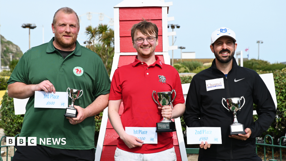 The image shows three men standing with trophies and certificates showing their podium placement. The winner, in the middle, is wearing a red shirt, the man in 2nd place on the right is wearing a black shirt and the last finalist on the left is wearing a green shirt. Behind them, bushes can be seen.