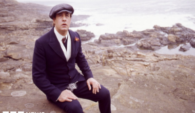 David appearing in Centre Play: God Bless Thee Jacky Maddison - Play by Tom Hadaway. Picture shows David Daker as Jacky Maddison. He is sat on rocks on a beach with a hat on.