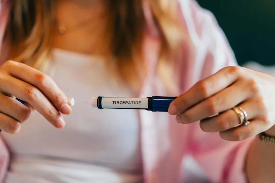 Person holding a Tirzepatide injection pen, used for diabetes management and weight loss