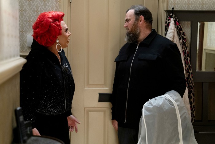566251,TITLE:Eastenders La Voix talks to a man in the Queen Victoria hallway in EastEnders