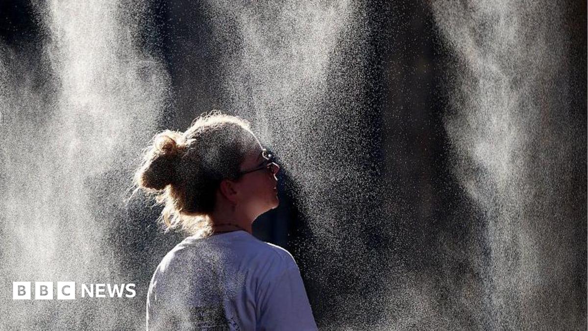 people under an umbrella because of the heat in paris with the Eiffel Tower in the background