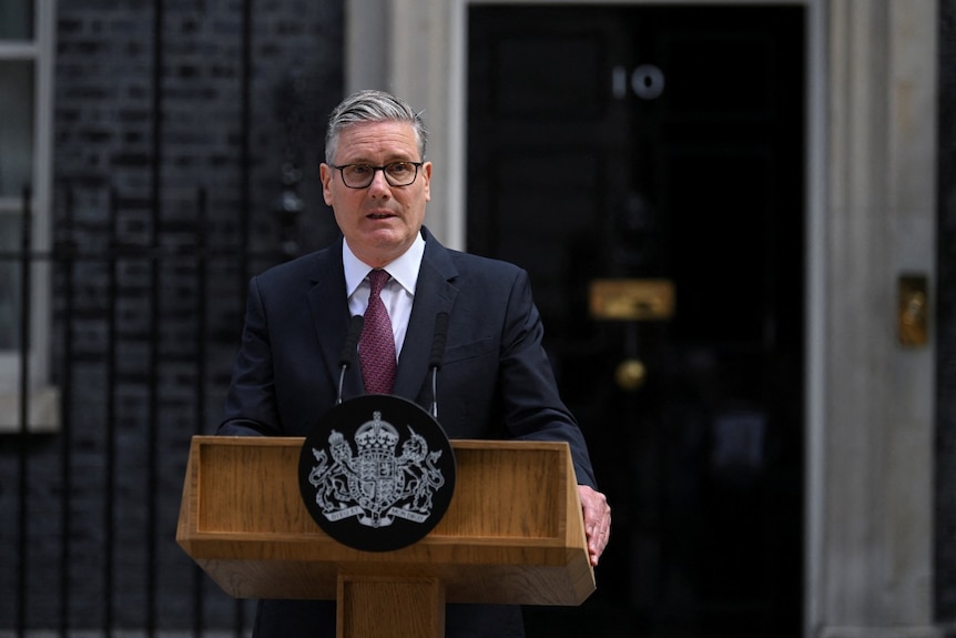 A man in a suit speaking at a lecturn.