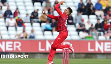 Chris Green, in red kit, in his delivery stride for Lancashire