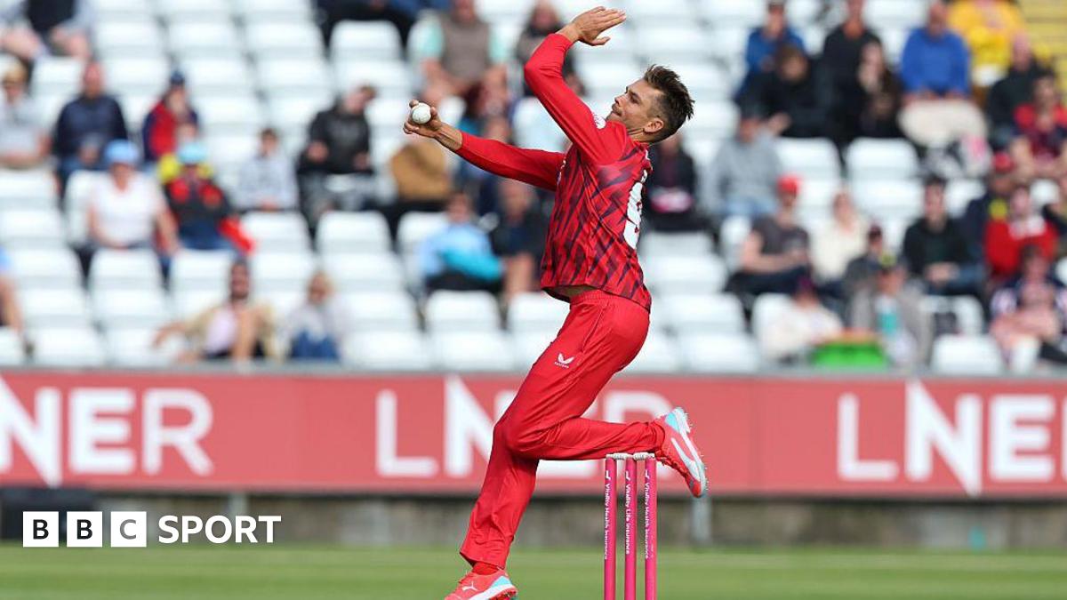 Chris Green, in red kit, in his delivery stride for Lancashire