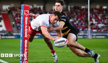 Hull KR winger Tom Davies reaches out with the ball in one hand as he dives towards the line under a challenge from a York Knight player