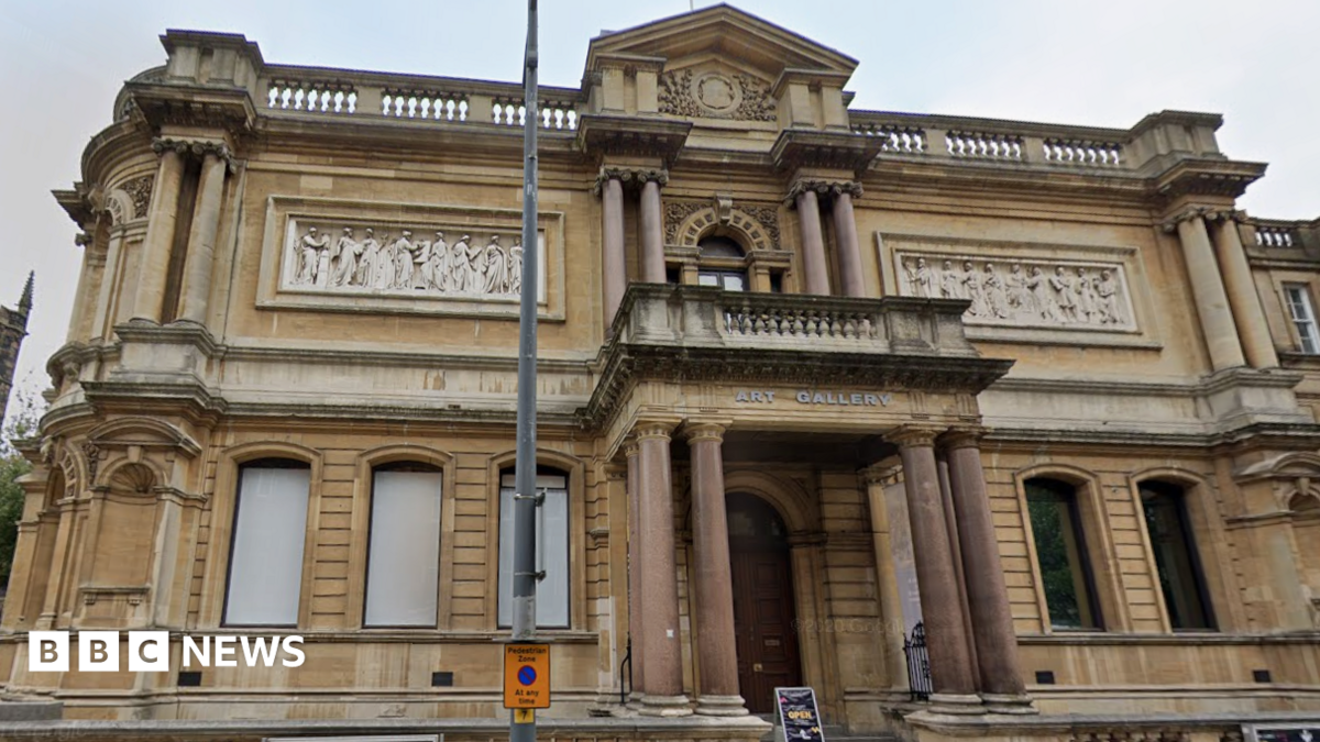 A photo of the exterior of a two-storey Victorian building which has a sign saying 'art gallery on it'. The building has marble pillars.