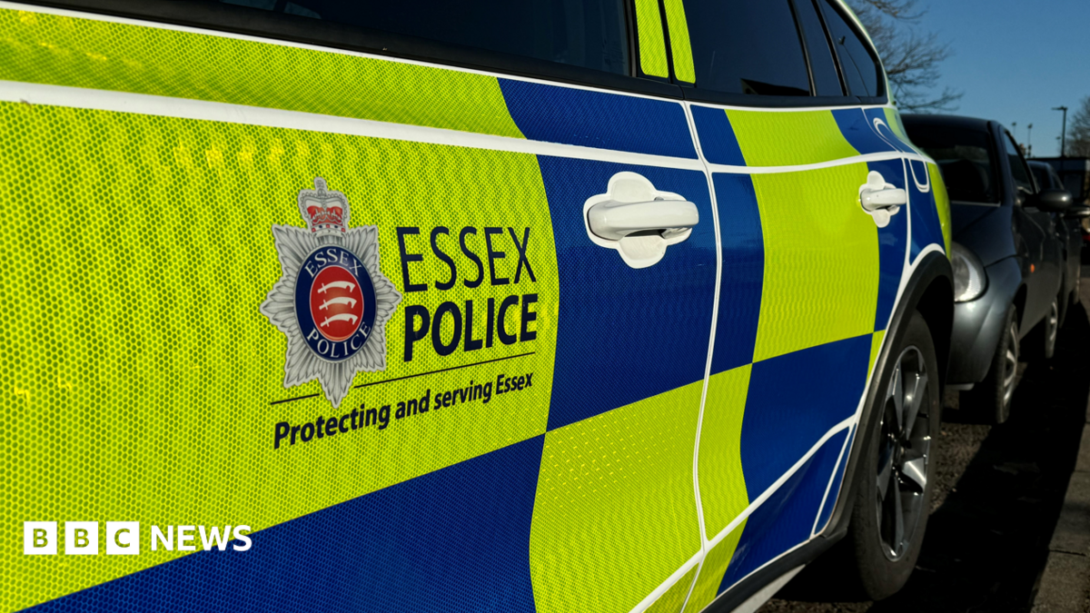 A Essex Police car parked. It has yellow and blue blocks of colour and the force logo on the side.