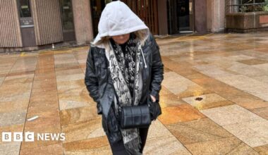 Helen Spree, 61, who has blonde hair, walks away from Liverpool Magistrates' Court with her hood pulled up and wearing a black coat.