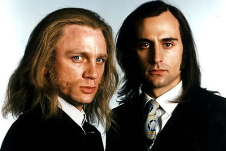 Two men with long hair wearing suits and ties