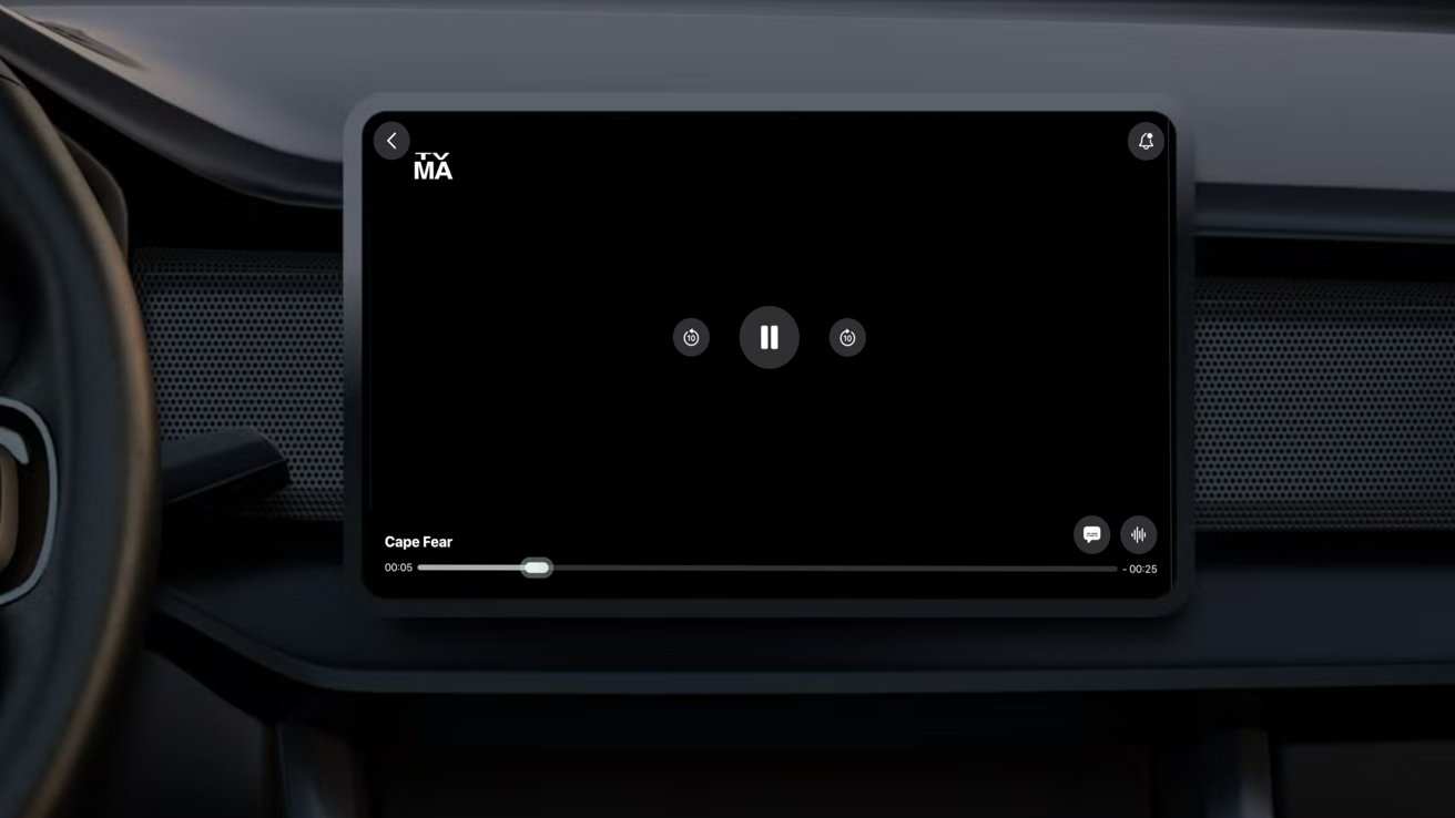 Car dashboard display screen showing a black media player interface with pause button centered, minimal controls along the bottom, and HBO Max logo in the upper left corner