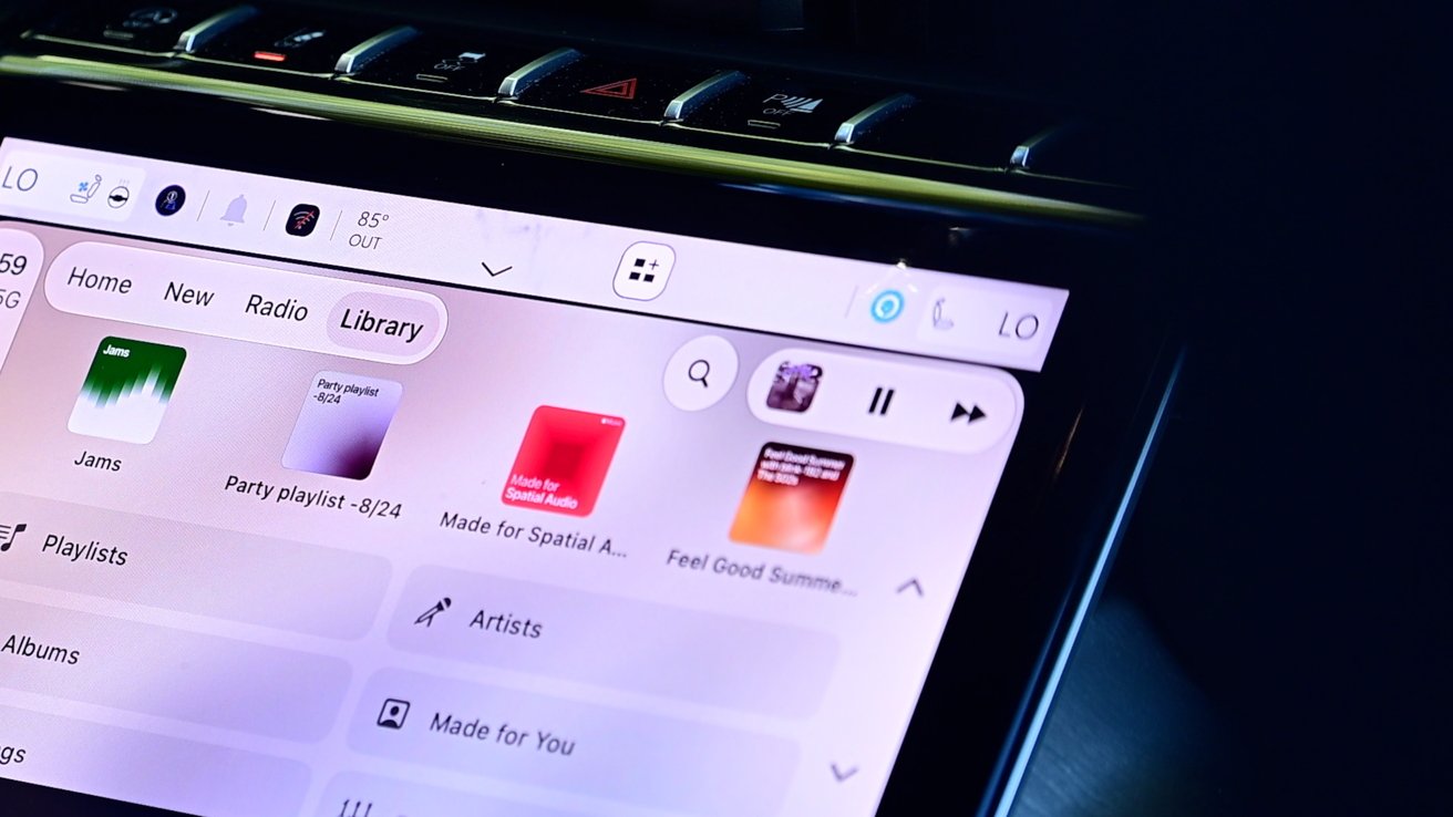 Close-up of a car's touchscreen infotainment system showing a music app library with colorful album covers, playlists, and playback controls in a dark, modern vehicle interior