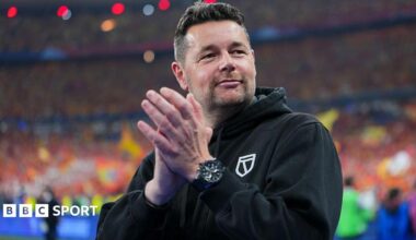 Pierre Sage, wearing a black hoodie while in charge of Lens, claps at the end of a game