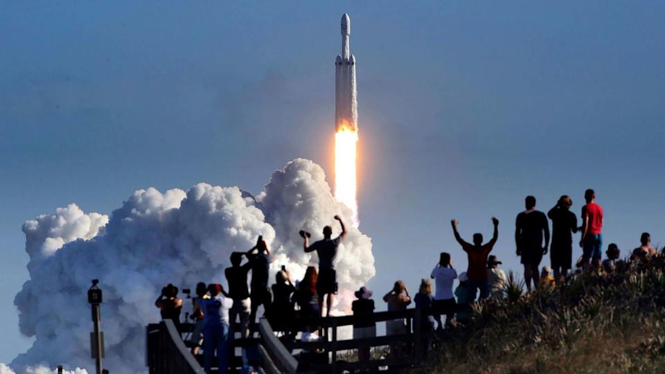 The crowd cheers at Playalinda Beach in the Canaveral National Seashore, just north of the Kennedy Space Center, during the launch of the SpaceX Falcon Heavy rocket, on Feb. 6, 2018.