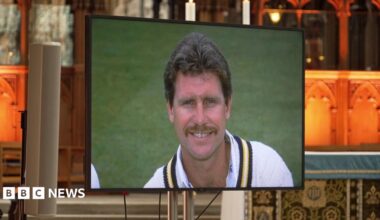 A screen in front of Winchester Cathedral's alter, with a head and shoulders picture of Robin Smith, smiling, in his cricket whites