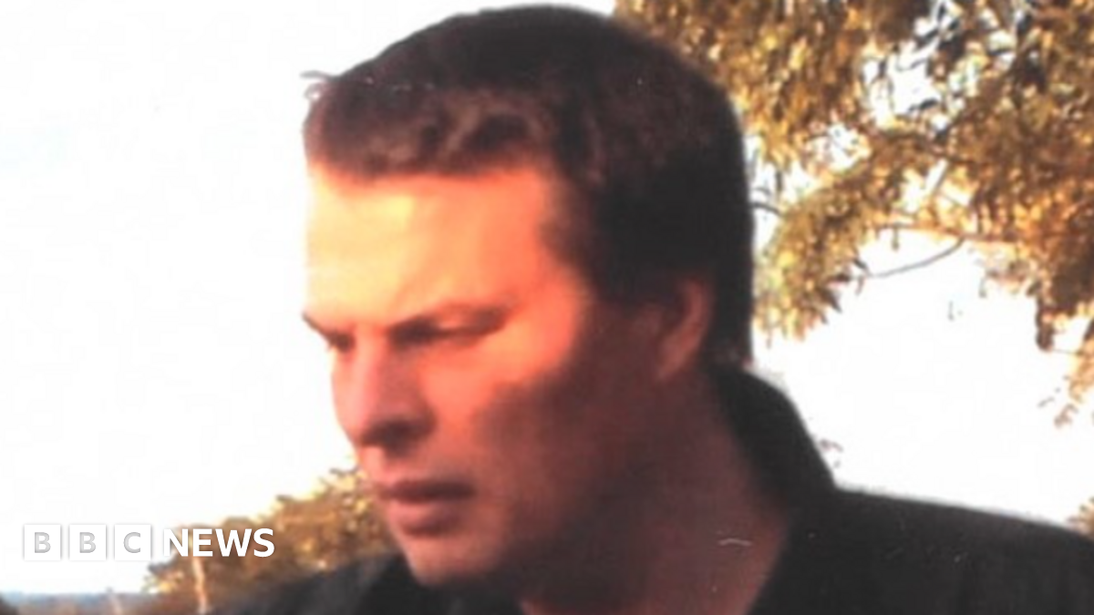 Darren Round pictured with brown hair wearing a blue and white stripe collar T-shirt and dark jacket.