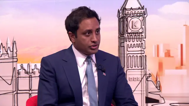 Reform UK spokesperson Zia Yusuf in a dark blue suit sitting on a red chair answering questions in a TV studio