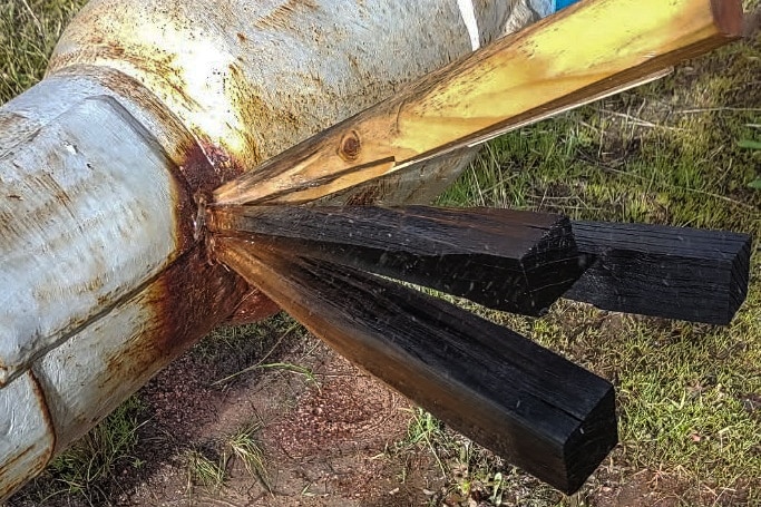 Wooden wedges inserted in a leaking water pipe