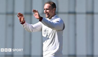 Liam Livingstone, wearing Lancashire cricket whites, celebrates with his hands held up to give a high-five and a smile on his face after taking a wicket against Kent