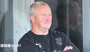 Sussex head coach Paul Farbrace, arms crossed, watches from a balcony in front of glass doors