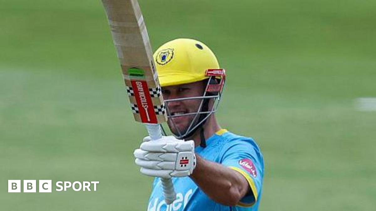 Warwickshire Bears' Beau Webster raising his bat in his left hand.