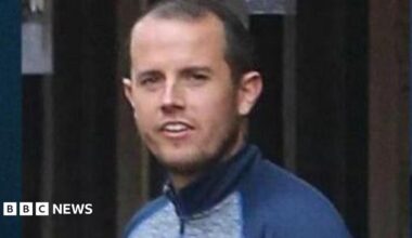 Sean McGovern is seen in a tracksuit top and has short black hair
