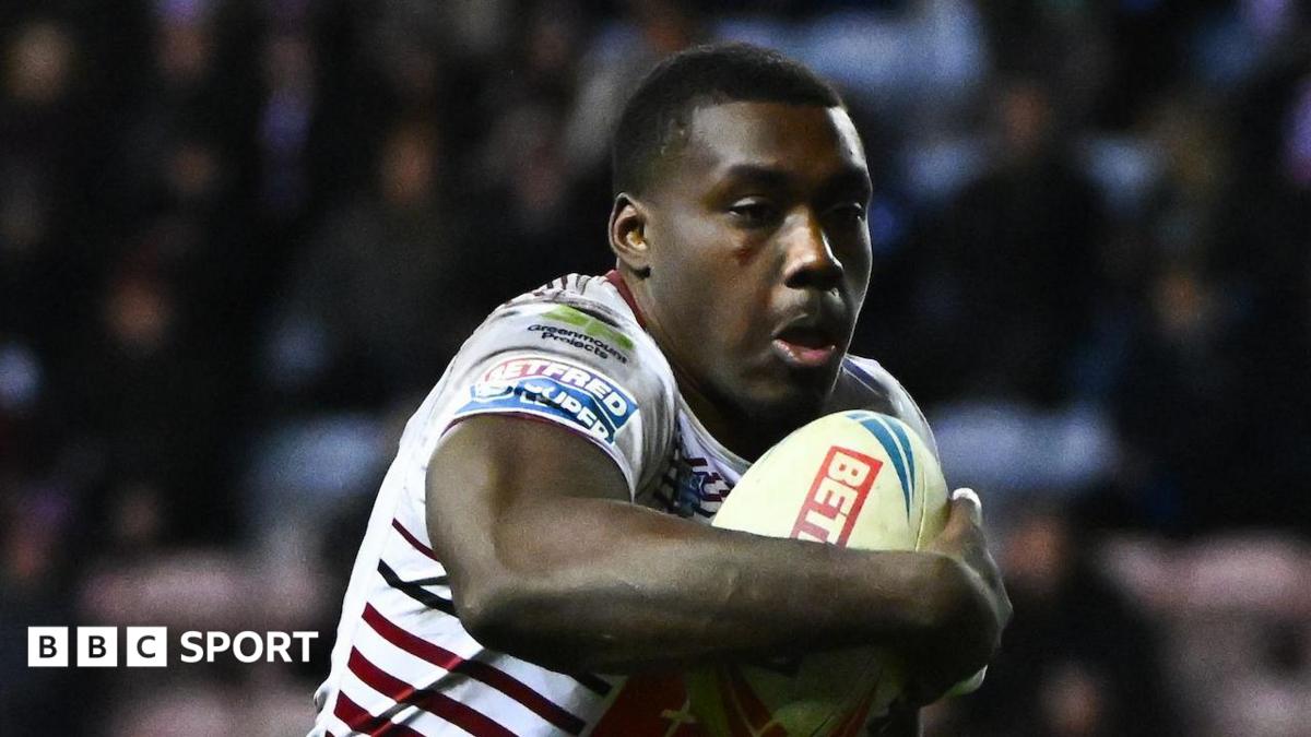 Sam Eseh playing for Wigan, carrying the rugby ball in his right arm