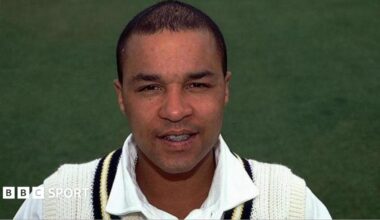 Head shot of Keith Piper wearing his white Warwickshire cricket jumper and shirt.