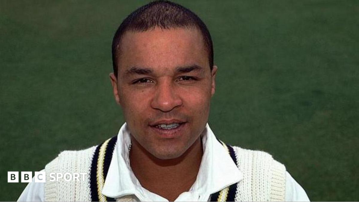 Head shot of Keith Piper wearing his white Warwickshire cricket jumper and shirt.